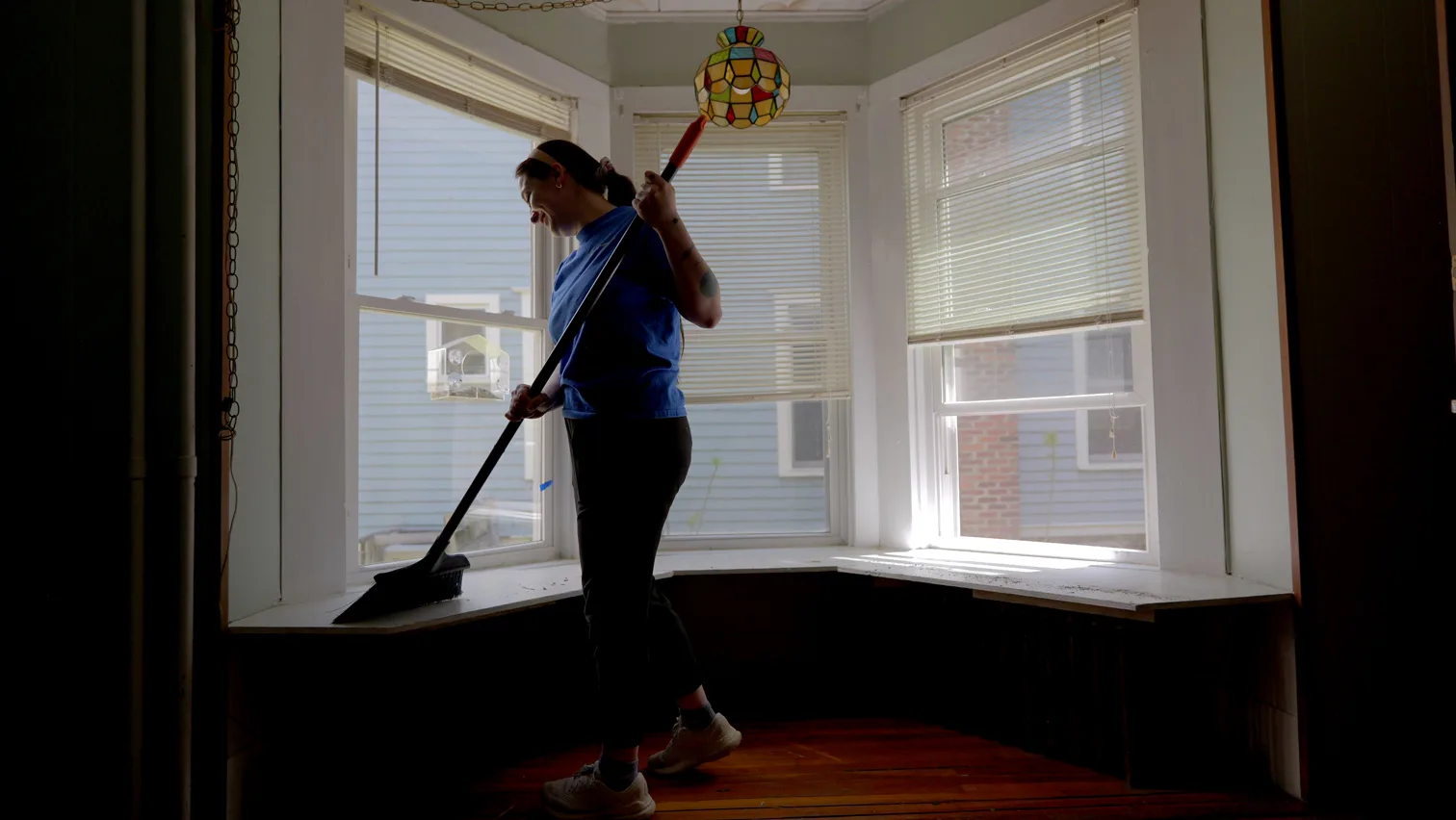 A cleaning woman sweeping dirt off a surface.